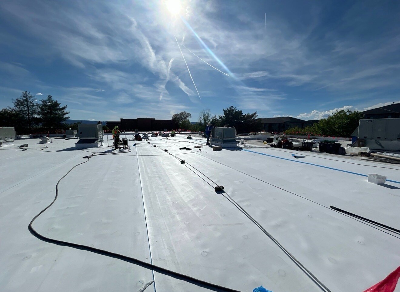 Wide TPO commercial roof installation in progress - RhinoBond induction welding setup across large commercial flat roof