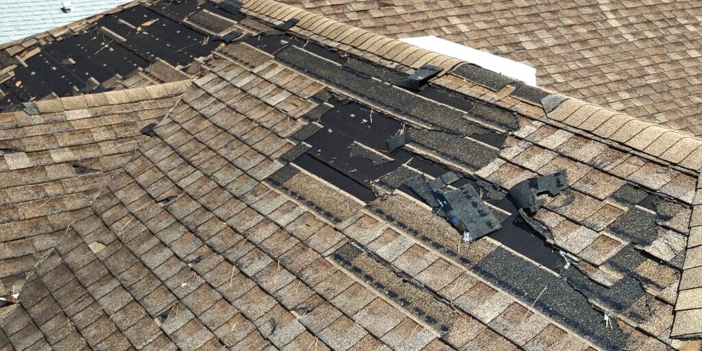 Wind damage - shingles completely blown off residential roof exposing underlayment