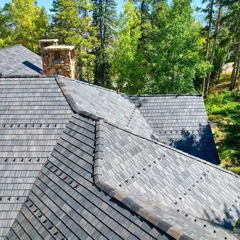 Dark slate roof against Colorado mountain backdrop - Impact Exteriors project